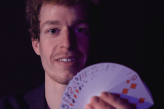 Der Zauberkünstler Max hält Spielkarten in der Hand