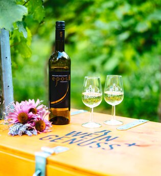 Weinflasche und zwei Weingläser stehen auf einer Holzkiste mit der Aufschrift WEIN GENUSS+ | © Biohof Döbler
