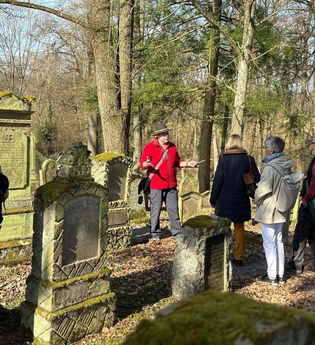 Eine Gruppe auf dem jüdischen Friedhof in Bad Rappenau Heinsheim. Ein Herr erklärt gerade etwas der Gruppe. | © Stadt Bad Rappenau