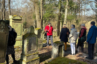 Eine Gruppe auf dem jüdischen Friedhof in Bad Rappenau Heinsheim. Ein Herr erklärt gerade etwas der Gruppe. | © Stadt Bad Rappenau