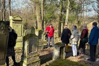 Eine Gruppe auf dem jüdischen Friedhof in Bad Rappenau Heinsheim. Ein Herr erklärt gerade etwas der Gruppe. | © Stadt Bad Rappenau
