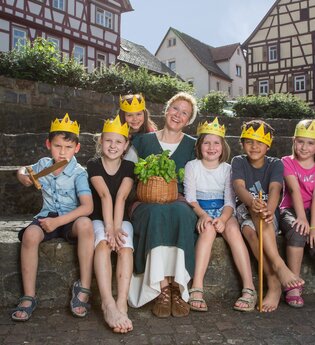 Kindergruppe mit selbst gebastelten Kronen und Gästeführerin | © Stadt Bad Wimpfen