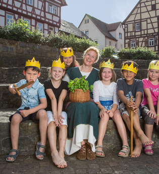 Kindergruppe mit selbst gebastelten Kronen und Gästeführerin | © Stadt Bad Wimpfen