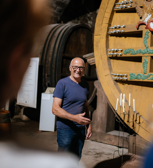 Museumsführer steht vor dem Weinfass. | © Hohenloher Perlen