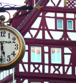 Halbe nach 5-Führungen, Uhr mit Fachwerkhaus im Hintergrund | © Stadt Eppingen