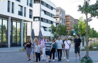 Eine Gruppe schlendert durch das neue Wohngebiet Neckarbogen