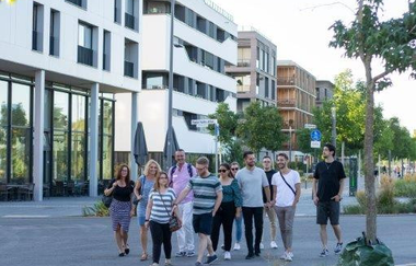 Eine Gruppe schlendert durch das neue Wohngebiet Neckarbogen