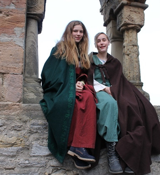 Kinderstadtführerinnen in historischer Aufmachung sitzen an den Arkaden des ehemaligen staufischen Palas | © Stadt Bad Wimpfen