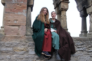 Kinderstadtführerinnen in historischer Aufmachung sitzen an den Arkaden des ehemaligen staufischen Palas | © Stadt Bad Wimpfen