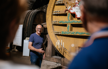 Museumsführer steht vor dem Weinfass. | © Hohenloher Perlen