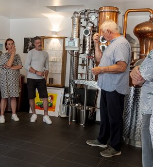Besuchergruppe in Ausstellung mit Brennkessel im Hintergrund