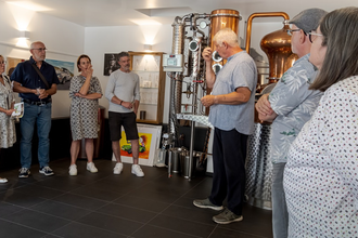 Besuchergruppe in Ausstellung mit Brennkessel im Hintergrund