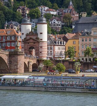 Solarschiff auf dem Neckar mit der Alten Brücke und Altstadt im Hintergrund