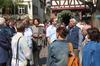 Personen stehen während einer Führung auf dem Marktplatz im Hintergrund Fachwerkgebäude | © Maria Zimmermann