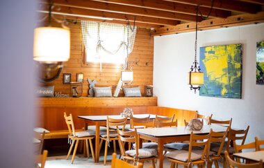Das Bild zeigt einen Raum mit weißen und Holzwänden. An der Decke kann man Holzbalken erkennen. Die Tische, Stühle und Eckbänke sind ebenfalls aus Holz. Auf den Tischen, auf den Stühlen und im Hintergrund sind viele gräuliche dekorative Elemente. | © Heilbronn Marketing GmbH