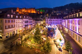 Winterwäldchen auf dem Kornmarkt mit weihnachtlichen Tannen und dem Heidelberger Schloss im Hintergrund. | © Heidelberg Marketing GmbH / Jan Becke