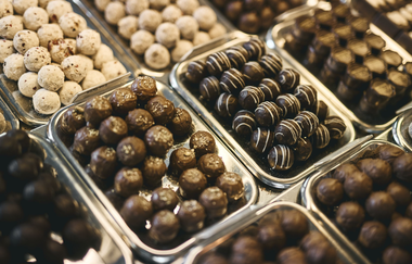 Auf unterschiedlichen kleinen Metalltablets liegen verschiedene Pralinen- und Schokoladenvariationen | © Tourimia Tourismus GmbH