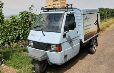 Eine Ape, das dreirädrige italienische Kultfahrzeug, parkt im Weinberg. Auf dem Dach eine Weinkiste. | © Die Weinschmeckerin Nicole Halter