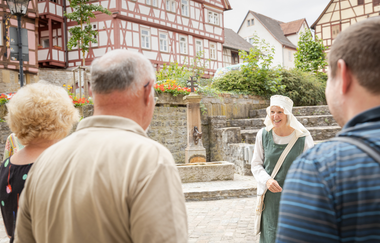 Kostümführung mit Gästegruppe im Spitalhof mit Sitalbrunnen und Risenhaus im Hintergrund | © Stadt Bad Wimpfen