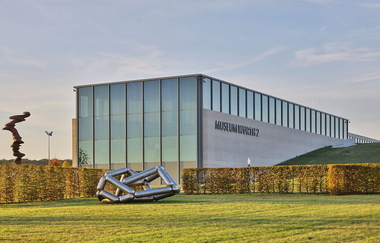 Das moderne Gebäude ist halb in die Erde gebaut, davor stehen zwei Skulpturen | © Touristikgemeinschaft Hohenlohe e. V. | Andi Schmid