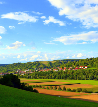 Ortsansicht von Mulfingen von Jagstberg aus mit Wiesen und Feldern | © Touristikgemeinschaft Hohenlohe e. V. | Andreas Schmelz
