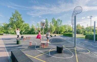 Kinder springen auf einem gepflasterten und bunten bemalten Spielfeld | © Stadt Sinsheim