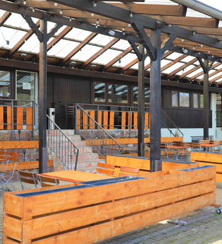 Terrasse mit Holztischen- und Stühlen