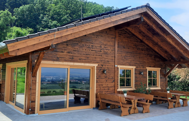 Im Außenbereich der Almhütte gibt es rustikale Sitzbänke | © Touristikgemeinschaft Hohenlohe e. V.  | Almhütte Weißlensberg