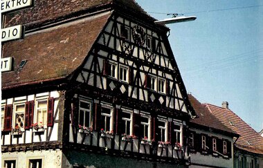 Ein Fachwerkhaus mit Blumenkästen an einer Straße