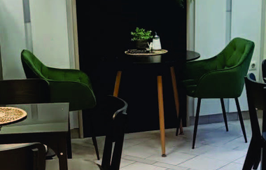 Moderne grüne und schwarze Stühle stehen im Innenbereich | © Hohenloher Perlen | Bäcker Trunk, Obersulm
