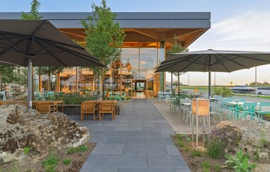 Die Außenterrasse ist mit hellen Stühlen und grauen Schirmen gestaltet. | © Touristikgemeinschaft Hohenlohe e. V. | Härdtner Bäckerei-Café N GmbH