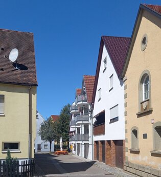 Straßenszene mit traditionellen Häusern und blauem Himmel. | © Petra Natzkowski