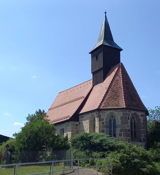 Bartholomäuskirche in Großaltdorf mit rotem Ziegeldach und Turm vor blauem Himmel. | © Petra Natzkowski