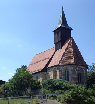 Bartholomäuskirche in Großaltdorf mit rotem Ziegeldach und Turm vor blauem Himmel. | © Petra Natzkowski