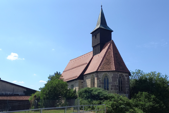 Bartholomäuskirche in Großaltdorf mit rotem Ziegeldach und Turm vor blauem Himmel. | © Petra Natzkowski