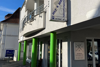 Außenansicht des Fahrradgeschäfts mit grünen Säulen