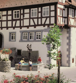 Fachwerkfassade mit Brunnen, in dem sich das Museum befindet | © Touristikgemeinschaft Hohenlohe e. V. | Eva Maria Kraiss