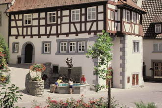 Fachwerkfassade mit Brunnen, in dem sich das Museum befindet | © Touristikgemeinschaft Hohenlohe e. V. | Eva Maria Kraiss