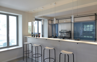 die Theke mit Barhockern ist schlicht weiß gehalten | © Touristikgemeinschaft Hohenlohe e. V. | Kocherwerk