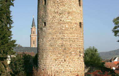 Der Blaue Hut, einer der Türme der ehemaligen Stadtbefestigung. Im Hintergrund ist der Turm der St. Laurentiuskirche zu sehen.