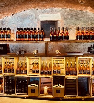 Ein Regal gefüllt mit Cidern im Ciderkeller | © Touristikgemeinschaft Hohenlohe e. V. | Anne Böhm