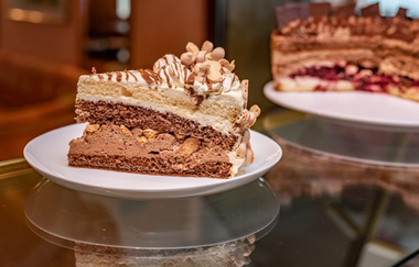 Hier ist ein Stück Wibeletorte auf einem Teller abgebildet. | © Cafe Bauer