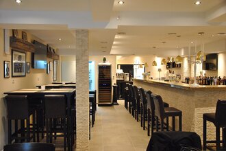 Der helle Innenräume verfügt über schwarze Barhocker an der Wand und um den Tresen | © Touristikgemeinschaft Hohenlohe e. V. | Café de Paris