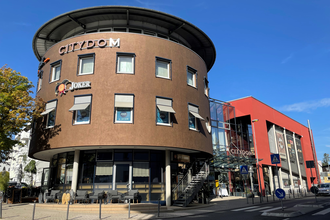 Moderner brauner Rundbau mit Kino und blauem Himmel