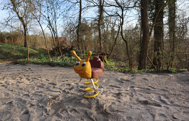 Blick auf ein Schaukeltier auf einem Sandplatz
