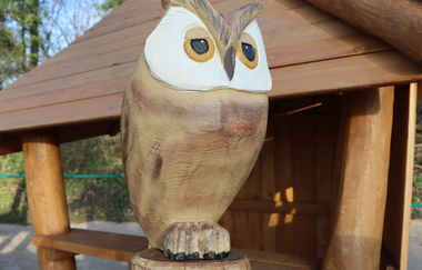 Blick auf die geschnitzte Holzeule an einem Spielgerät des Spielplatzes