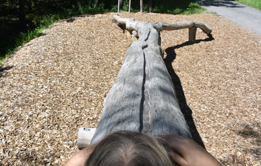 Ein Kind spielt an einer hölzernen Murmelbahn auf Holzspänen | © Stadt Sinsheim