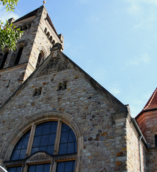 Zu sehen ist der obere Teil der Peterskirche über dem Hauptportal. | © TI Weinheim