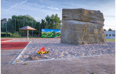Große Sandspielfläche mit Steinblock und einem kleinen Sandspielzeug | © Stadt Sinsheim