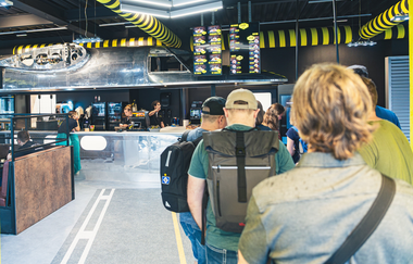 Menschen in einer Schlange vor dem Tresen des Flight Decks | © Technik Museum